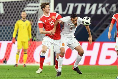 El ruso Aleksey Miranchuk y el jugador español Sergio Busquets luchan por hacerse con la posesión del balón.