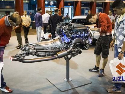 Varias personas observan un motor en el Sal&oacute;n del Autom&oacute;vil de Madrid