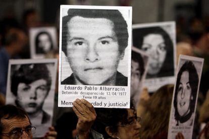 Manifestantes y familiares de víctimas de la dictadura argentina muestran imágenes de varios desaparecidos en una concentración en Buenos Aires en 2009.