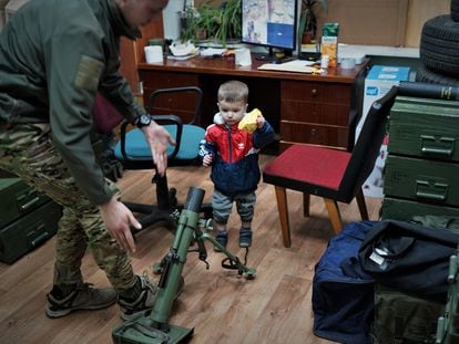 El hijo de un comandante del Batallón Azov en un almacén de armas junto a un miliciano en una base de este movimiento en Kiev, el 3 de abril.