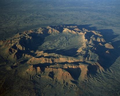 Conocido como Tnorala por los aborígenes que habitan en esta región del centro de Australia, el cráter  Gosses Bluff  forma un anillo de colinas de casi cinco kilómetros de diámetro, causado por el impacto de un asteroide hace unos 140 millones de años. Lo primero que sorprende al visitante es el verdor de la reserva protegida Tnorala, que engloba el lugar en un entorno árido, desértico de tierra rojiza. En un viaje de un par de días se puede aprovechar para conocer también el impresionante monolito rojo Uluru, a unos 200 kilómetros al suroeste.