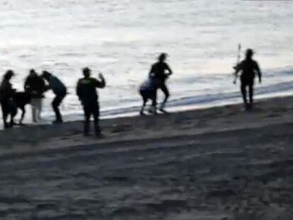 Captura de un vídeo en la que varios guardias civiles devuelven inmigrantes a Marruecos desde la playa de Tarajal, en Ceuta, en 2014.