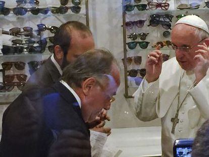 El Papa se prueba unas gafas en la tienda de Alessandro Spiezia (en primer término).