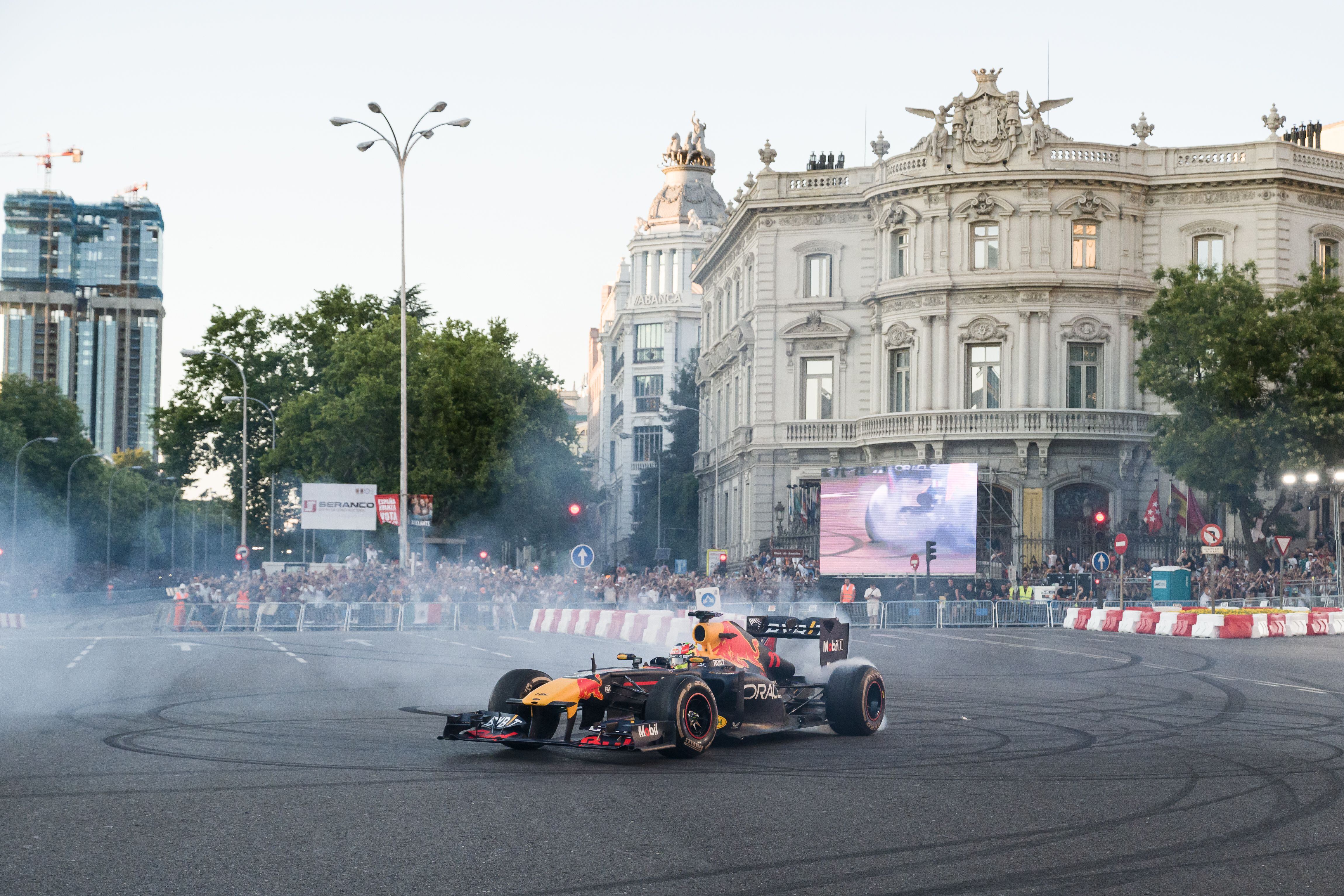 El piloto de F1 Checo Perez recorre con el monoplaza ‘Red Bull RB7 (2011)’ el recorrido urbano entre la Puerta de Alcalá, el edificio Metrópolis, Cibeles y un tramo de Paseo Recoletos, a 15 de julio de 2023, en Madrid (España). 