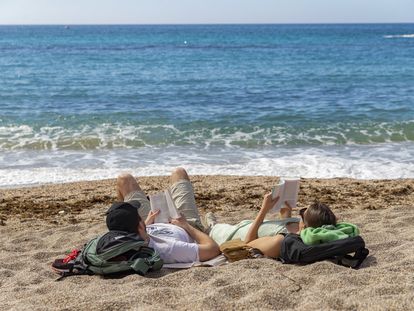 Una pareja toma el sol mientras lee, este miércoles en la playa de Cala Cortina de Cartagena (Murcia).