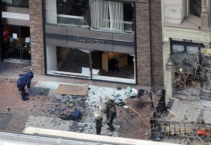 Expertos en explosivos analizan el lugar de la calle Boylston donde ha explotado una de las bombas.
