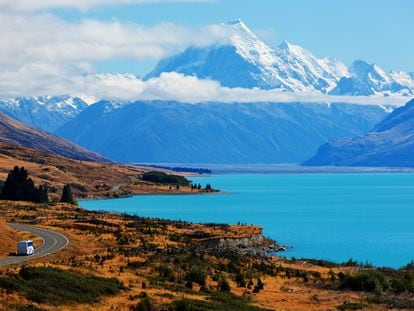 Una caravana serpenteando por la carretera, bordeando el Lago Pukaki. De fondo, el Monte Cook, en Nueva Zelanda.