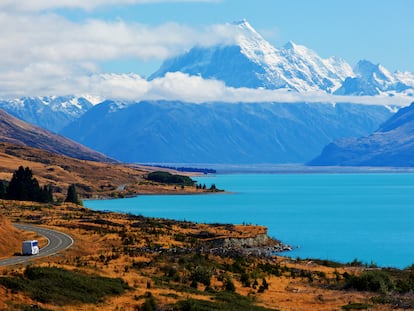 Una caravana serpenteando por la carretera, bordeando el Lago Pukaki. De fondo, el Monte Cook, en Nueva Zelanda.