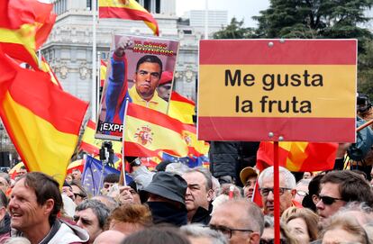 Asistentes a la concentración sostienen imágenes contra el presidente del Gobierno.