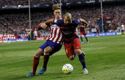 Mascherano es disputa amb Torres la pilota.