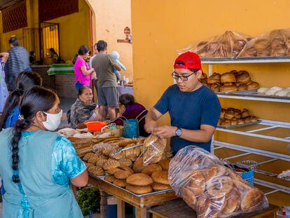 Dos mujeres compran pan en un puesto en un mercado de Oaxaca.