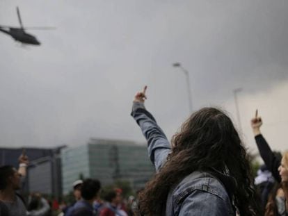 Manifestantes gesticulan contra un helicóptero de la policía. En vídeo, imágenes de las protestas en Bogotá