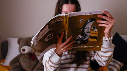 Una niña estudia Geografía e Historia en un libro en inglés.