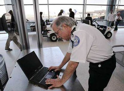 Un agente revisa un ordenador en el aeropuerto de Newark (Nueva York).