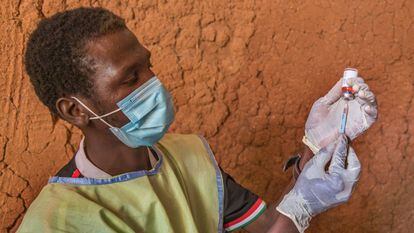 Un médico de una unidad móvil coloca la vacuna en una jeringuilla para administrarla a un niño en un asentamiento en Toro, Nigeria, en octubre de 2020.