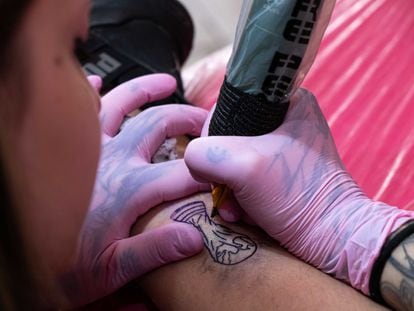 Una tatuadora traza una imagen de la Copa del Mundo en la pierna de un cliente, en el Coven Tatoo Studio en Olivos, Buenos Aires, el 27 December 2022.