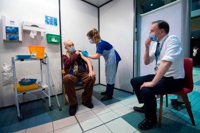 El director del Servicio Nacional de Salud, Simon Stevens, observa cómo un paciente recibe la vacuna de Pfizer, este martes en el Hospital Guy de Londres.