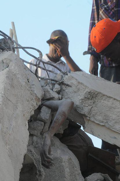 Un cuerpo atrapado entre los escombros de un edificio en la capital haitiana.
