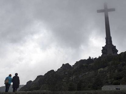 Dos turistas, este martes, ante la cruz del Valle de los Caídos.