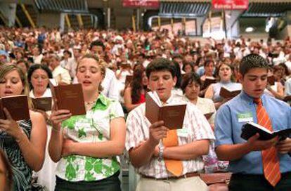 Testigos de Jehová realizan sus cánticos y rezos durante la celebración de la asamblea anual en el Palau Sant Jordi de Barcelona.