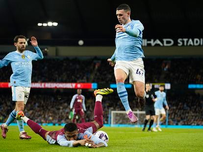 Phil Foden, del City, salta junto a Diego Carlos el miércoles pasado durante el City-Aston Villa de Premier.