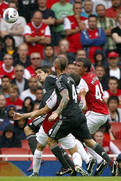 Luis Suárez, Meireles y Miquel pugnan por un balón aéreo.