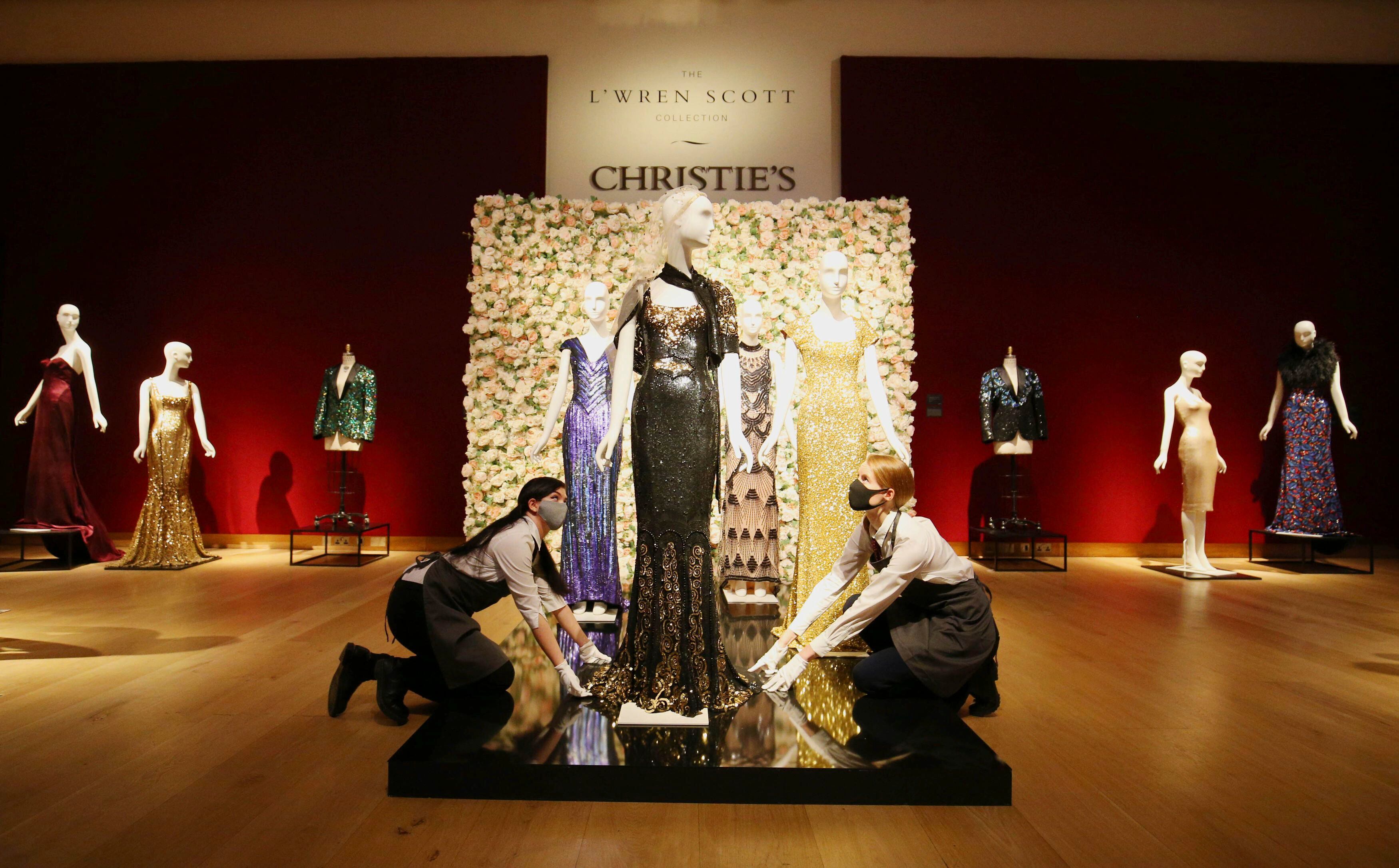 Personal de Christie's retoca los maniquíes con las prendas de L'Wren Scott vendidas en subasta en Londres.