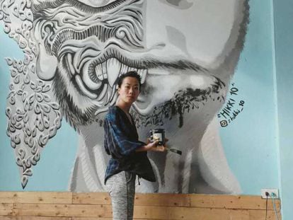 La artista Luanna Lee, junto a una de sus creaciones en un albergue en Bangkok (Tailandia), en la pasada primavera.