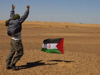 Un miembro del Frente Polisario se manifiesta ante los soldados marroqu&iacute;es, al fondo de la imagen,  apostados en el muro constru&iacute;do por Marruecos.