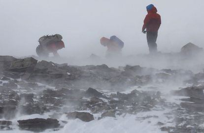 Los científicos chilenos Sebastián Vega (i) y Sandra Troncoso (c) y un explorador militar (d) buscan muestras de líquenes en las colinas de Bucharan en el Glaciar Unión, situado en las montañas Ellsworth, en la Antártida, el 26 de noviembre de 2018.
