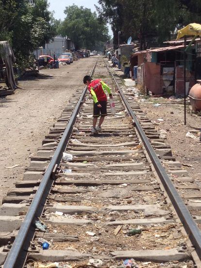 Un niño camina por una vía de tren en Ecatepec.