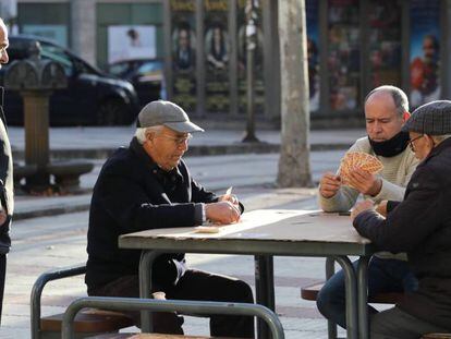 Un grupo de hombres juega a las cartas en una calle de Madrid.
