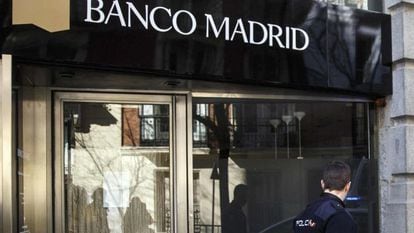 Un policía pasa frente a una entidad del Banco Madrid, intervenido en 2015.