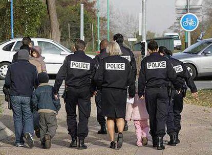Miembros de la policía francesa de fronteras acompañan a una familia a la salida del tribunal de Cergy.