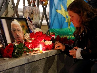 Una mujer enciende una vela frente a un retrato del jefe de los mercenarios de Wagner, Yevgueni Prigozhin, en un monumento improvisado en Moscú, este jueves.
