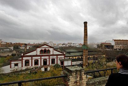 Una mujer observa el complejo industrial de la antigua fábrica de vidrio La Trinidad de Sevilla.