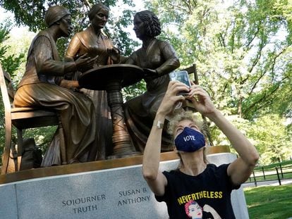 Una mujer se hace una foto frente a una estatua que honra los derechos de la mujer, entre ellos el derecho al voto, en Central Park.