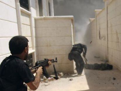 Un miembro del Ej&eacute;rcito Libre de Siria cubre a un compa&ntilde;ero durante una ofensiva en la ciudad de Khanasar, este lunes.