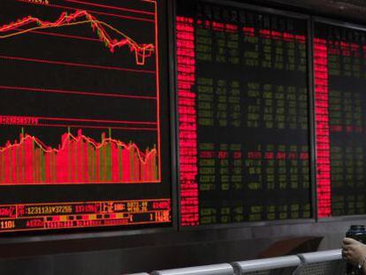 Un inversor contempla el rojo panorama del mercado burs&aacute;til chino en Shang&aacute;i