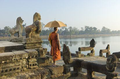Monje budista al lado de las piedras talladas de Angkor Wat (Camboya).