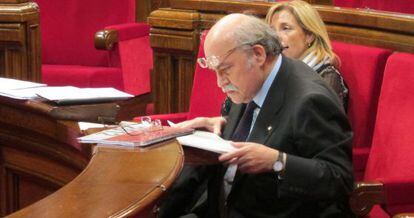 El consejero de Economía, Andreu Mas-Colell, revisa documentación en el escaño del Parlament.