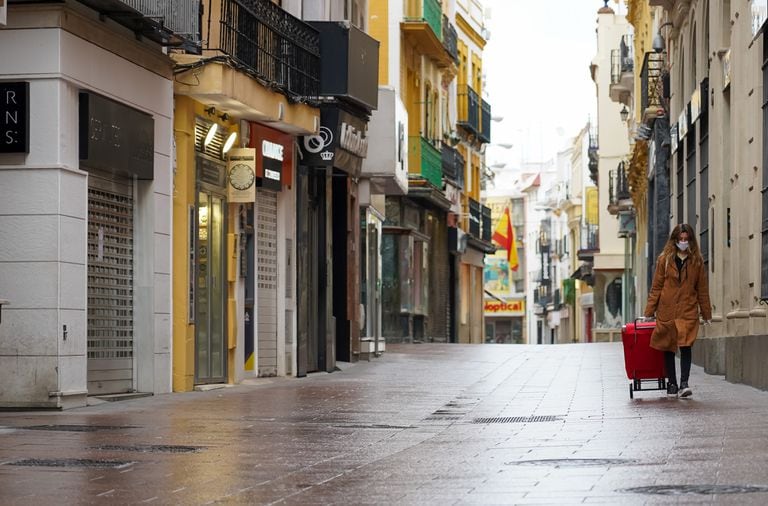Una mujer camina por una calle vacía en Sevilla, el lunes.