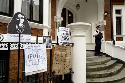 Un polic&iacute;a vigila la embajada ecuatoriana en Londres, donde simpatizantes de Assange han colgado letreros.