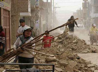 La familia Nolasco desescombra su vivienda destruida por el terremoto en la localidad peruana de Imperial.