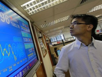 Un hombre consulta una pantalla informativa con los datos de la bolsa en Hong Kong (China). 