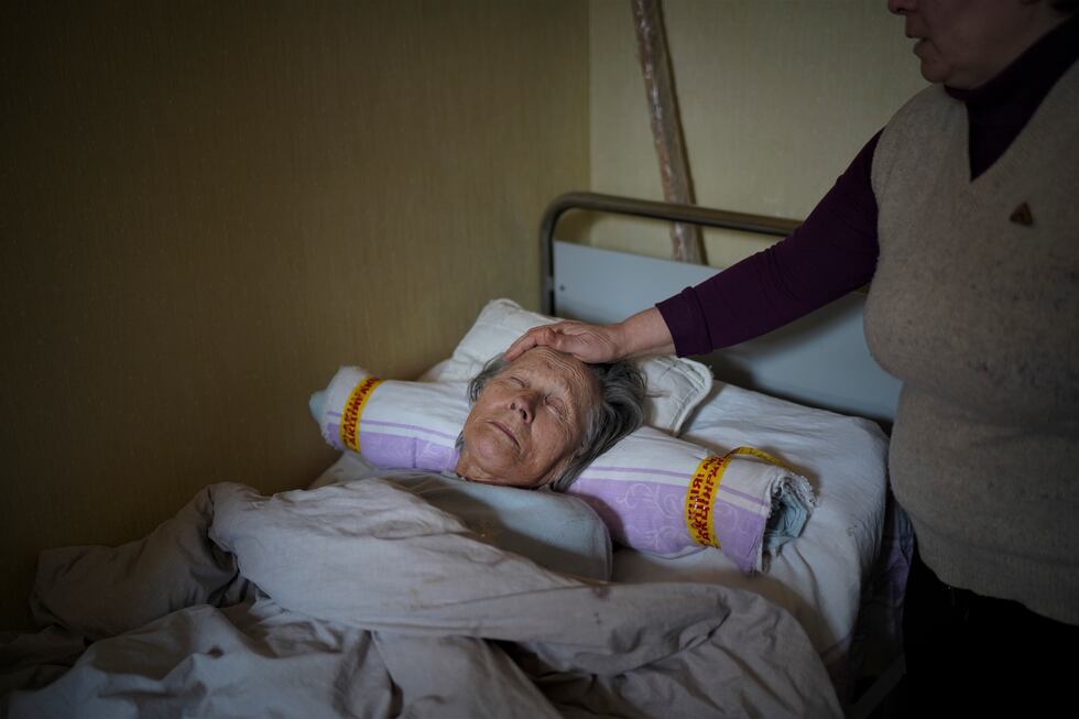 Yana Nikolaevna, de 80 años, se ha quedó sola en su piso de Kiev al empezar la guerra.v. Solo la atiende Katia, una vecina de 50 años que, cuando la deja dormida en su casa, en una sexta planta, se baja a pasar la noche al refugio del sótano. FOTO: LUIS DE VEGA