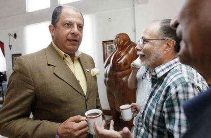 El candidato del PAC, Luis Guillermo Solís, habla con unos periodistas.