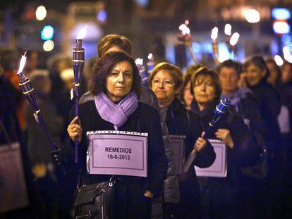 Un grupo de mujeres porta antorchas y esquelas en recuerdo de las víctimas de violencia de género.