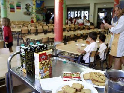Dos trabajadoras y varios alumnos en un comedor escolar.