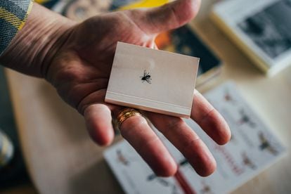 Detalle de un pequeño libro con una mosca impresa.